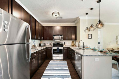 Example of a mid-sized transitional u-shaped dark wood floor open concept kitchen design in Orlando with a double-bowl sink, recessed-panel cabinets, dark wood cabinets, quartz countertops, beige backsplash, stainless steel appliances and a peninsula