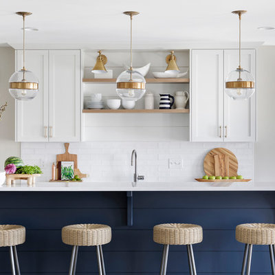 Inspiration for a transitional galley ceramic tile open concept kitchen remodel in Minneapolis with shaker cabinets, white cabinets, quartz countertops, white backsplash, stainless steel appliances, white countertops, an undermount sink, subway tile backsplash and an island