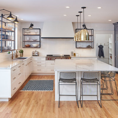 Example of a large transitional l-shaped light wood floor kitchen design in Minneapolis with an undermount sink, white cabinets, quartzite countertops, white backsplash, subway tile backsplash, stainless steel appliances, an island, white countertops and recessed-panel cabinets
