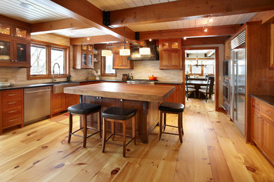 Large transitional u-shaped light wood floor eat-in kitchen photo in Minneapolis with an undermount sink, beaded inset cabinets, medium tone wood cabinets, granite countertops, beige backsplash, stone tile backsplash, stainless steel appliances and an island