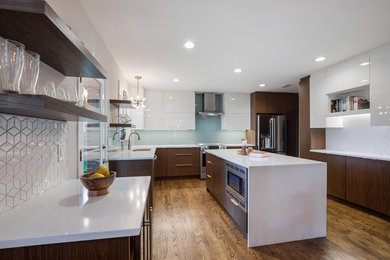 Inspiration for a mid-sized contemporary u-shaped light wood floor and brown floor eat-in kitchen remodel in Jacksonville with an undermount sink, flat-panel cabinets, white cabinets, quartz countertops, blue backsplash, glass tile backsplash, stainless steel appliances, an island and white countertops