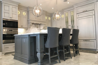 Example of a large transitional l-shaped porcelain tile and gray floor eat-in kitchen design in Toronto with an undermount sink, white cabinets, quartz countertops, white backsplash, mosaic tile backsplash, an island, white countertops, recessed-panel cabinets and paneled appliances