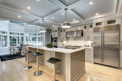 Open concept kitchen - large traditional l-shaped light wood floor open concept kitchen idea in Boston with a double-bowl sink, recessed-panel cabinets, gray cabinets, marble countertops, white backsplash, marble backsplash, stainless steel appliances and an island