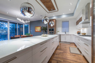Inspiration for a large modern l-shaped dark wood floor and brown floor eat-in kitchen remodel in Vancouver with an undermount sink, flat-panel cabinets, white cabinets, quartzite countertops, stainless steel appliances, an island and white countertops