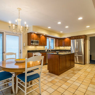 Design ideas for a mid-sized traditional u-shaped separate kitchen in Other with an undermount sink, raised-panel cabinets, medium wood cabinets, granite benchtops, stainless steel appliances, ceramic floors, with island, yellow floor and black benchtop.