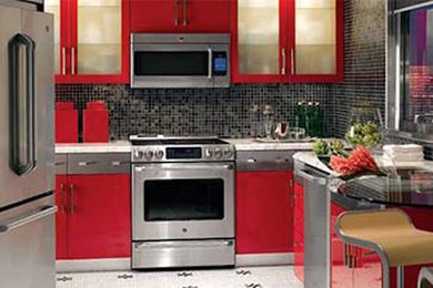 Kitchen - l-shaped ceramic tile kitchen idea in New York with flat-panel cabinets, red cabinets, multicolored backsplash and glass tile backsplash