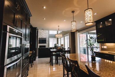 Mid-sized minimalist u-shaped porcelain tile and beige floor eat-in kitchen photo in Toronto with recessed-panel cabinets, black cabinets, granite countertops, gray backsplash, subway tile backsplash, stainless steel appliances, an island and multicolored countertops