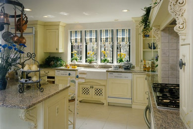 マイアミにあるラグジュアリーな広いトラディショナルスタイルのおしゃれなキッチン (エプロンフロントシンク、落し込みパネル扉のキャビネット、黄色いキャビネット、御影石カウンター、ベージュキッチンパネル、白い調理設備、セラミックタイルの床) の写真