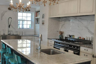 Mid-sized trendy u-shaped eat-in kitchen photo in Minneapolis with a farmhouse sink, beaded inset cabinets, white cabinets, marble countertops, white backsplash, stone slab backsplash, stainless steel appliances, an island and white countertops