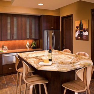 Design ideas for a large u-shaped eat-in kitchen in Minneapolis with an undermount sink, flat-panel cabinets, dark wood cabinets, onyx benchtops, red splashback, mosaic tile splashback, stainless steel appliances, porcelain floors, with island, brown floor and orange benchtop.