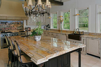 Example of a huge classic l-shaped ceramic tile and beige floor eat-in kitchen design in Austin with a farmhouse sink, raised-panel cabinets, distressed cabinets, granite countertops, an island, multicolored backsplash, stone slab backsplash and stainless steel appliances
