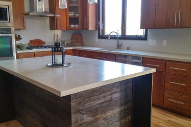 Eat-in kitchen - mid-sized transitional l-shaped light wood floor eat-in kitchen idea in Other with an undermount sink, flat-panel cabinets, medium tone wood cabinets, concrete countertops, white backsplash, stainless steel appliances and an island