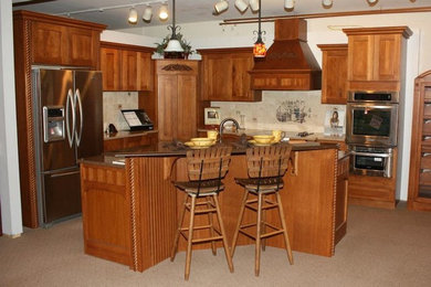 Mid-sized l-shaped eat-in kitchen photo in Other with recessed-panel cabinets, medium tone wood cabinets, stainless steel appliances and an island