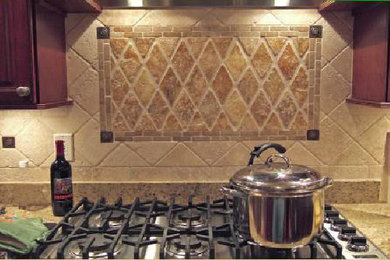 Diseño de cocina mediterránea con armarios con paneles empotrados, puertas de armario de madera en tonos medios, encimera de granito, salpicadero beige, salpicadero con mosaicos de azulejos y electrodomésticos de acero inoxidable