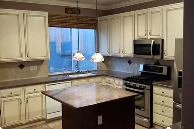Eat-in kitchen - mid-sized traditional l-shaped ceramic tile eat-in kitchen idea in Las Vegas with a double-bowl sink, beaded inset cabinets, white cabinets, laminate countertops, beige backsplash, ceramic backsplash, stainless steel appliances and an island
