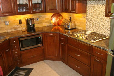 Photo of a medium sized contemporary u-shaped kitchen in Cleveland with granite worktops and beige splashback.