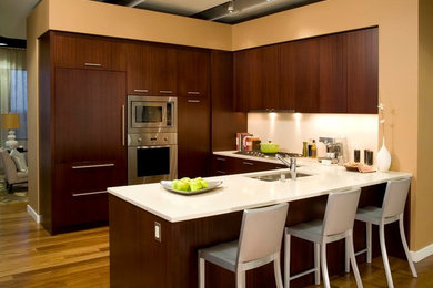 Eat-in kitchen - mid-sized transitional u-shaped medium tone wood floor eat-in kitchen idea in New York with a double-bowl sink, flat-panel cabinets, dark wood cabinets, quartzite countertops, white backsplash, glass sheet backsplash, stainless steel appliances and no island