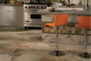 Example of a large transitional single-wall travertine floor eat-in kitchen design in St Louis with flat-panel cabinets, gray cabinets, concrete countertops, multicolored backsplash, stone tile backsplash, stainless steel appliances and a peninsula