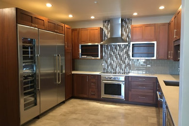 Example of a mid-sized trendy u-shaped vinyl floor and beige floor eat-in kitchen design in Denver with an undermount sink, shaker cabinets, medium tone wood cabinets, quartz countertops, gray backsplash, glass tile backsplash, stainless steel appliances and no island