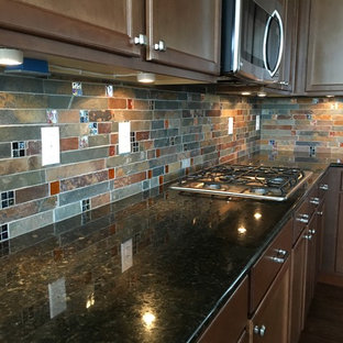 Inspiration for a country kitchen in Denver with recessed-panel cabinets, dark wood cabinets, granite benchtops, multi-coloured splashback, slate splashback, stainless steel appliances, dark hardwood floors and brown floor.