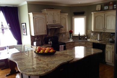 Küche mit Rückwand aus Stein, hellem Holzboden und Kücheninsel in St. Louis