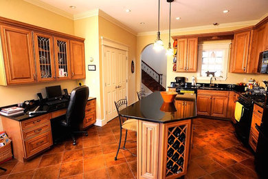 Geschlossene, Mittelgroße Urige Küche in L-Form mit profilierten Schrankfronten, hellbraunen Holzschränken, schwarzen Elektrogeräten und Kücheninsel in Portland Maine