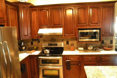 This is an example of a kitchen in Nashville with flat-panel cabinets, medium wood cabinets and an island.