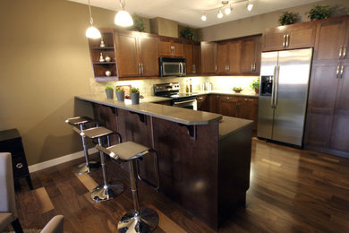 Photo of a kitchen in Baltimore with a built-in sink, flat-panel cabinets, dark wood cabinets, granite worktops, stainless steel appliances and dark hardwood flooring.