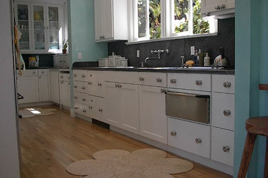 Inspiration for a mid-sized transitional u-shaped light wood floor eat-in kitchen remodel in San Francisco with a drop-in sink, flat-panel cabinets, white cabinets, granite countertops, stainless steel appliances, an island, gray backsplash and stone slab backsplash