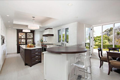 Large transitional u-shaped porcelain tile and white floor eat-in kitchen photo in San Diego with an undermount sink, shaker cabinets, white cabinets, stainless steel appliances and an island