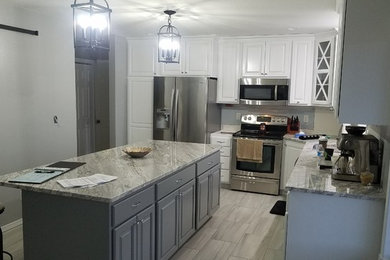 Example of a mid-sized transitional l-shaped porcelain tile and beige floor enclosed kitchen design in Other with a double-bowl sink, raised-panel cabinets, white cabinets, granite countertops, stainless steel appliances, an island and gray countertops