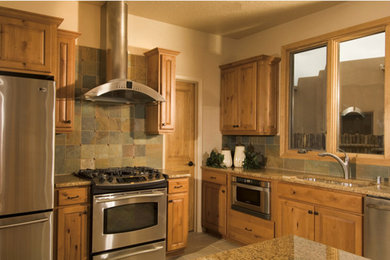 Exempel på ett avskilt, mellanstort amerikanskt l-kök, med en undermonterad diskho, luckor med upphöjd panel, skåp i mellenmörkt trä, granitbänkskiva, grått stänkskydd, stänkskydd i stenkakel, rostfria vitvaror, klinkergolv i keramik, en köksö och beiget golv