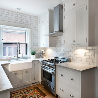 Traditional enclosed kitchen ideas - Enclosed kitchen - traditional l-shaped light wood floor enclosed kitchen idea in Denver with a farmhouse sink, shaker cabinets, white cabinets, marble countertops, white backsplash, subway tile backsplash and stainless steel appliances