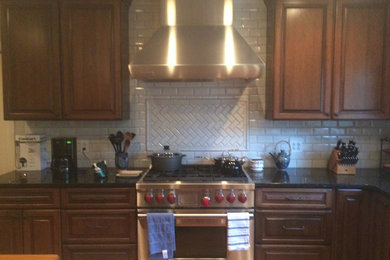 Inspiration for a mid-sized timeless l-shaped eat-in kitchen remodel in Atlanta with an undermount sink, raised-panel cabinets, stainless steel cabinets, granite countertops, white backsplash, subway tile backsplash, stainless steel appliances and an island