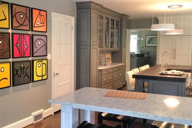 Example of a mid-sized classic u-shaped dark wood floor eat-in kitchen design in Baltimore with a farmhouse sink, recessed-panel cabinets, gray cabinets, marble countertops, stainless steel appliances and two islands