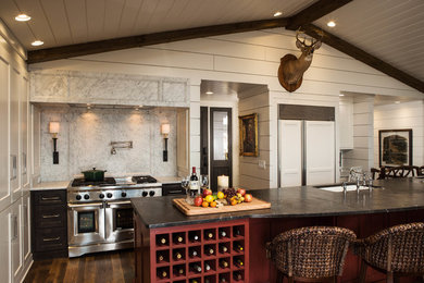 Esempio di un cucina con isola centrale country di medie dimensioni con lavello sottopiano, ante in stile shaker, ante in legno bruno, top in marmo e paraspruzzi bianco