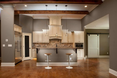 Example of a mid-sized classic l-shaped dark wood floor and brown floor open concept kitchen design in Nashville with raised-panel cabinets, white cabinets, beige backsplash, ceramic backsplash, stainless steel appliances and an island