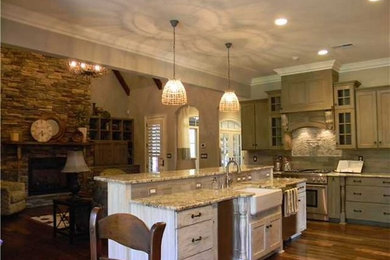 Open concept kitchen - large traditional u-shaped dark wood floor and brown floor open concept kitchen idea in Nashville with a farmhouse sink, shaker cabinets, gray cabinets, granite countertops, beige backsplash, stainless steel appliances and an island