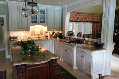 Large elegant galley marble floor and beige floor enclosed kitchen photo in Other with a double-bowl sink, raised-panel cabinets, white cabinets, granite countertops, ceramic backsplash and an island