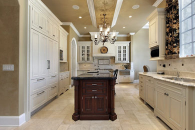 Inspiration for a large transitional galley porcelain tile enclosed kitchen remodel in Wichita with a drop-in sink, recessed-panel cabinets, white cabinets, granite countertops, beige backsplash, ceramic backsplash, stainless steel appliances and an island
