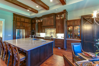 Inspiration for a mid-sized craftsman l-shaped dark wood floor eat-in kitchen remodel in Orange County with an undermount sink, shaker cabinets, dark wood cabinets, marble countertops, gray backsplash, ceramic backsplash, stainless steel appliances and an island
