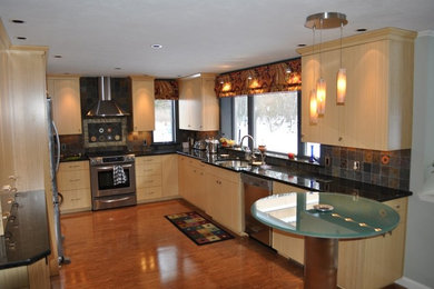 Example of a large trendy l-shaped dark wood floor and brown floor eat-in kitchen design in Portland Maine with an undermount sink, flat-panel cabinets, light wood cabinets, quartz countertops, multicolored backsplash, stone tile backsplash, stainless steel appliances, a peninsula and black countertops