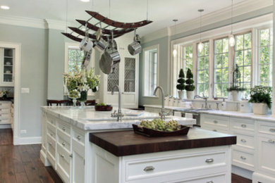 Inspiration for a large contemporary single-wall dark wood floor and brown floor enclosed kitchen remodel in San Francisco with an undermount sink, beaded inset cabinets, white cabinets, marble countertops, stainless steel appliances and an island
