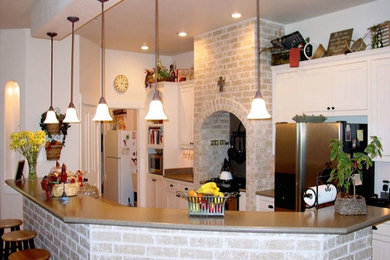Inspiration for a mid-sized timeless single-wall open concept kitchen remodel in Austin with flat-panel cabinets, white cabinets, white backsplash, stainless steel appliances and an island