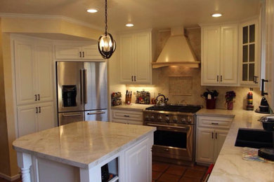 Example of a small classic u-shaped ceramic tile and brown floor eat-in kitchen design in San Francisco with an undermount sink, raised-panel cabinets, white cabinets, marble countertops, beige backsplash, mosaic tile backsplash, stainless steel appliances and an island