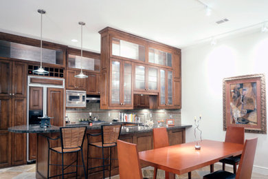 Example of a mid-sized classic u-shaped eat-in kitchen design in Dallas with raised-panel cabinets, medium tone wood cabinets, granite countertops, stainless steel appliances and a peninsula