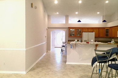 Mid-sized u-shaped ceramic tile eat-in kitchen photo in Jacksonville with medium tone wood cabinets, white appliances and no island
