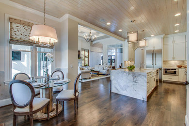 Inspiration for a large transitional l-shaped dark wood floor open concept kitchen remodel in New Orleans with a farmhouse sink, shaker cabinets, white cabinets, marble countertops, white backsplash, stone slab backsplash, stainless steel appliances and an island