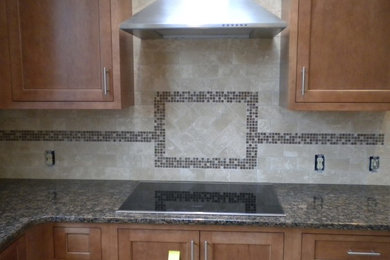 Mid-sized l-shaped kitchen photo in Philadelphia with medium tone wood cabinets, granite countertops, beige backsplash, ceramic backsplash and stainless steel appliances