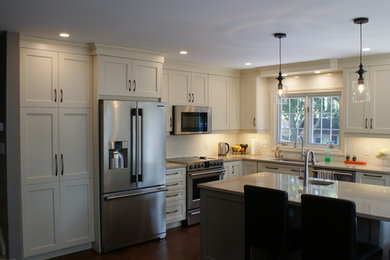 Example of a large transitional l-shaped eat-in kitchen design in Toronto with an undermount sink, shaker cabinets, white cabinets, quartz countertops, white backsplash, subway tile backsplash, stainless steel appliances and an island